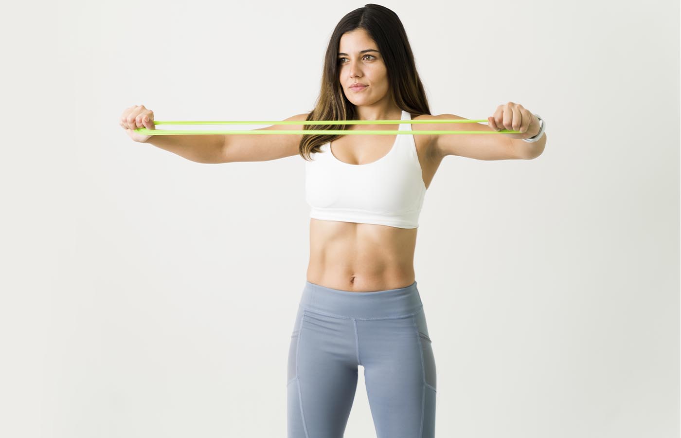 Woman stretching resistance band over chest